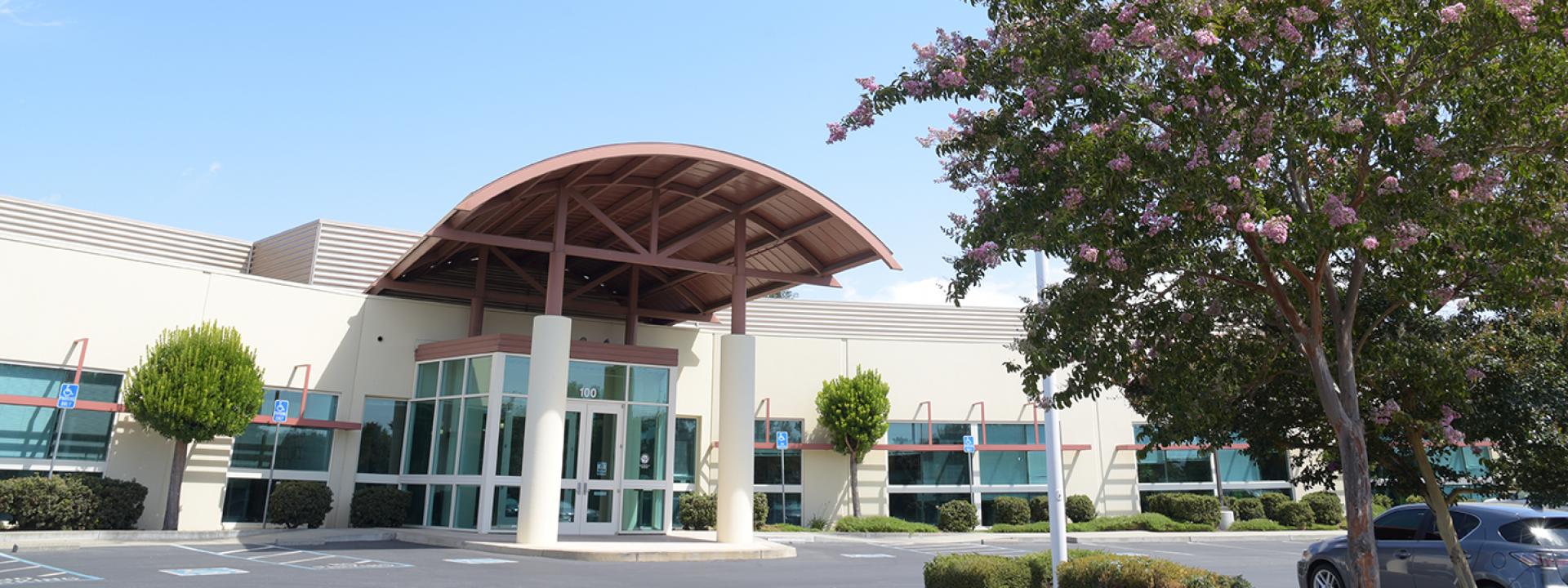 The front of Zone 7's administrative building with blue sky, cloud, and trees