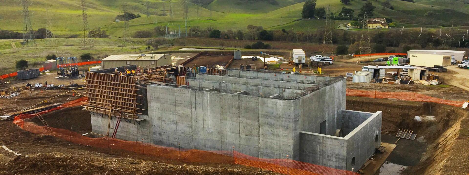 Construction site with cement building being worked on.