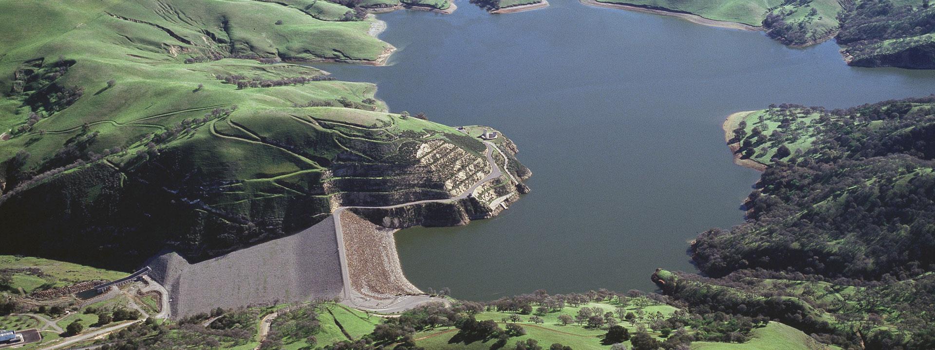 Dark blue lake in the middle of green hills and ridges