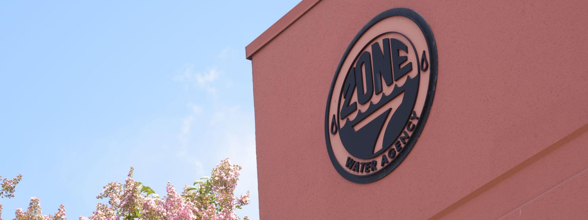 Close up of Zone 7 Headquarter building showing Zone 7 logo on the right hand side, a tree with pink flowers can be seen in the background