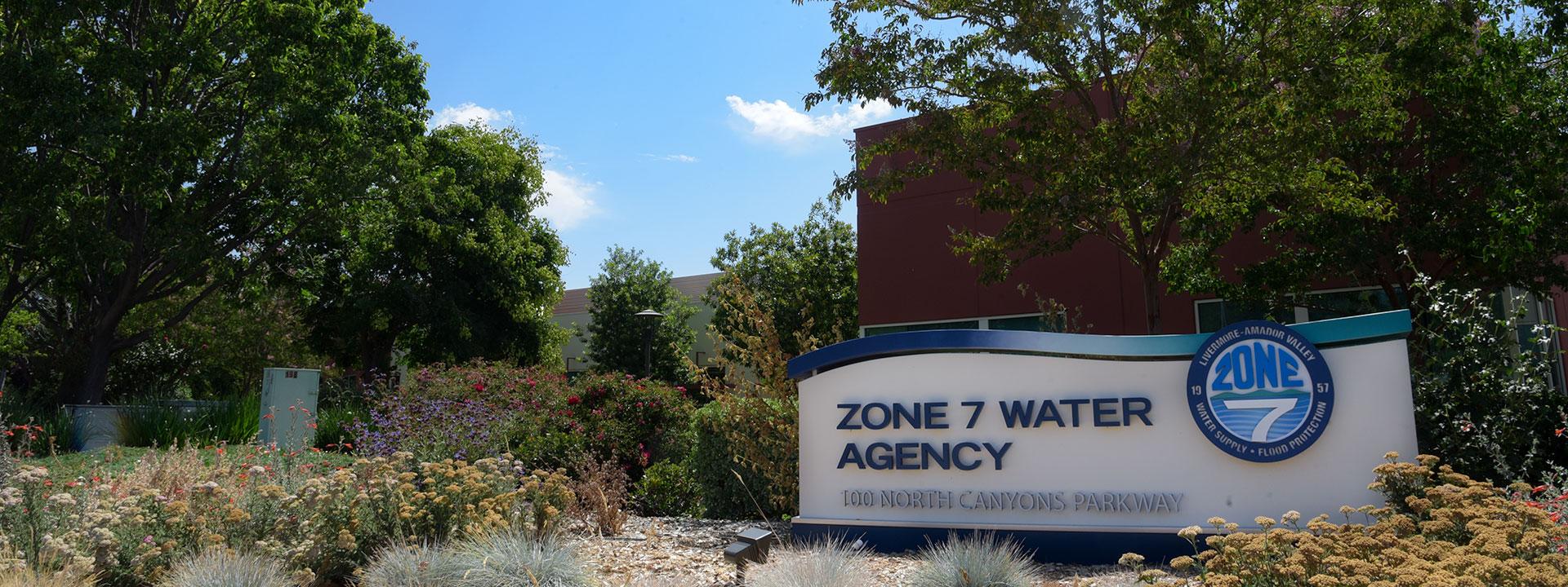 The Zone 7 Water Agency Headquarters monument sign in front of trees and a blue sky in the background