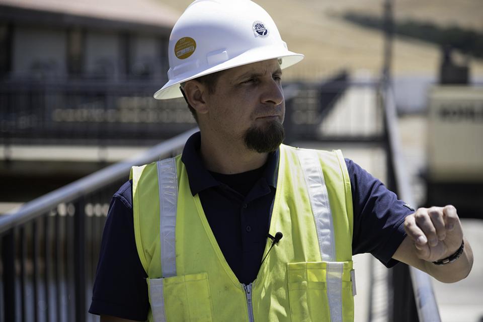 Zone 7 employee wearing a hard hat and safety vest outside