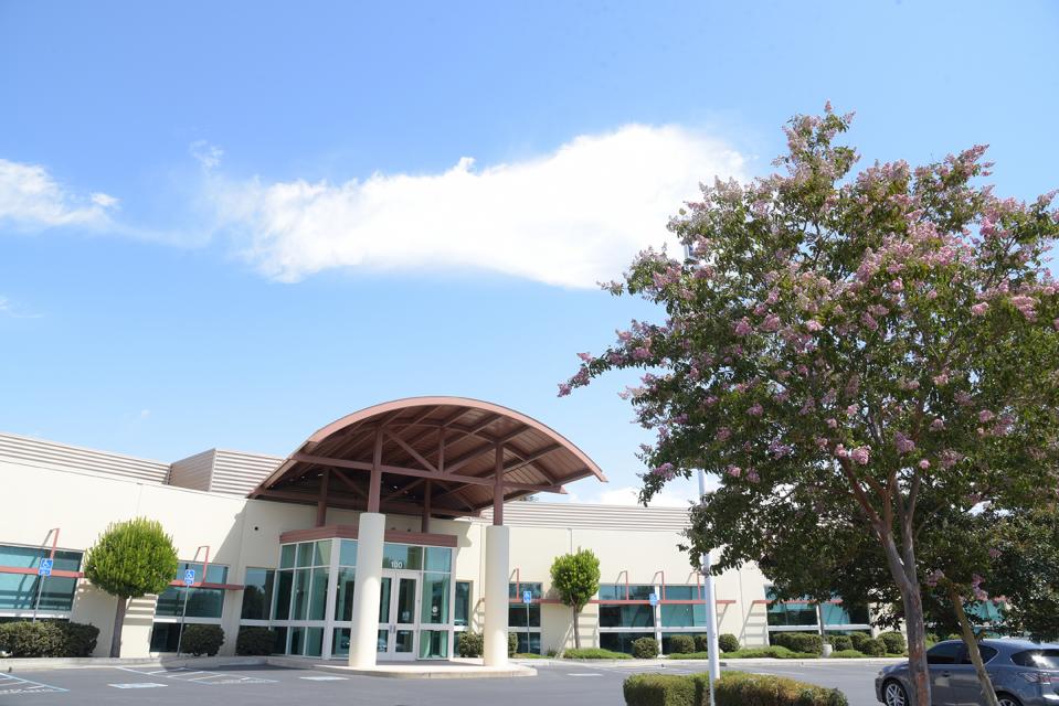 The front of Zone 7's administrative building with blue sky, cloud, and trees