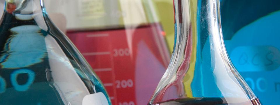 Test tubes and glass beakers filled with different colored liquids.