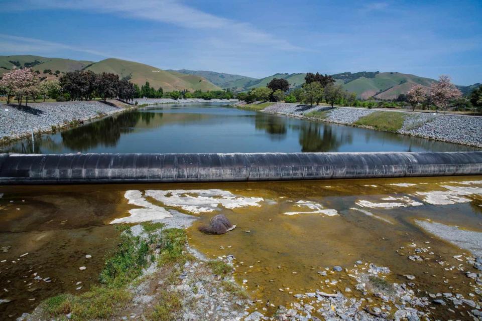 Alameda Creek with a view of the fish ladder and hills in the background.