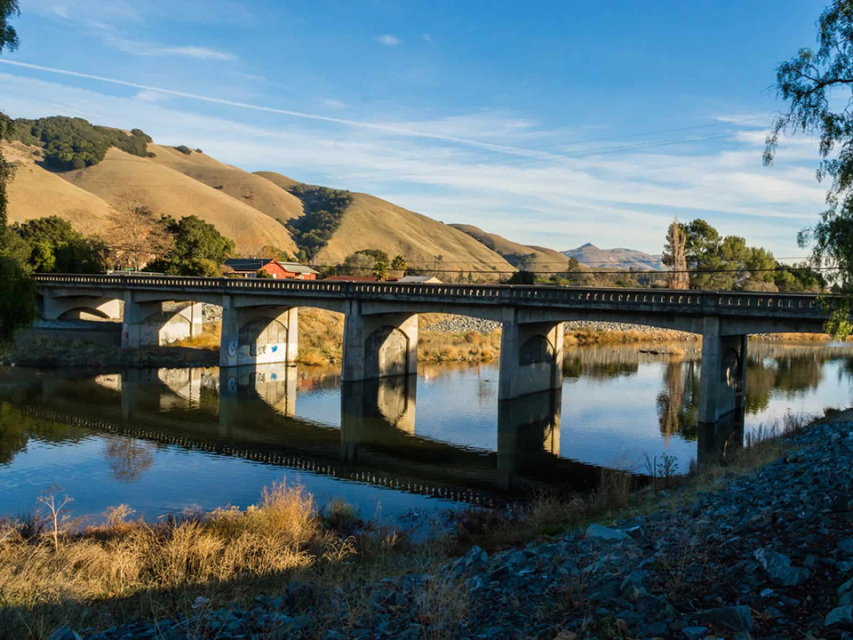 Alameda Creek with bridge, golden hills in the background.