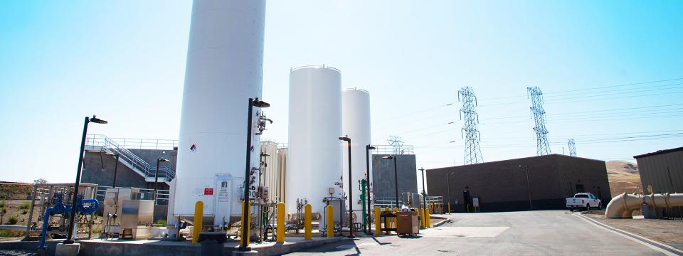 Three large white tanks holding liquid oxygen