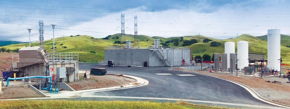 Del Valle Water Treatment Plant amidst grassy hills.