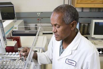 Zone 7 employee holding test tubes and facing water quality equipment