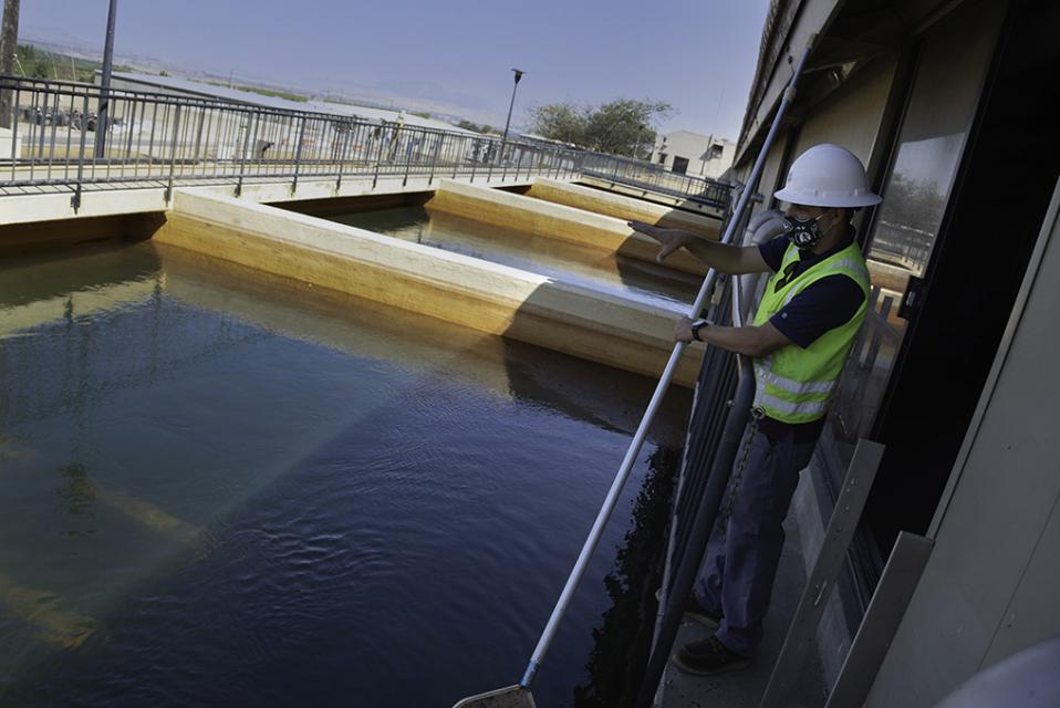 Zone 7 Water Agency Employee with hard hat and safety vest running net through water