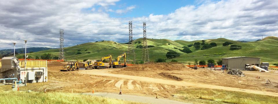 Area of Del Valle Water Treatment plant with powerlines and green hills in the background