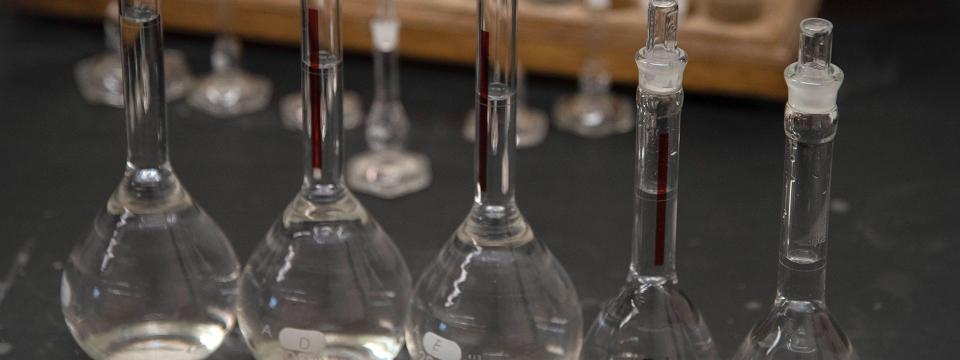 Close up of test tubes and beakers filled with a clear liquid