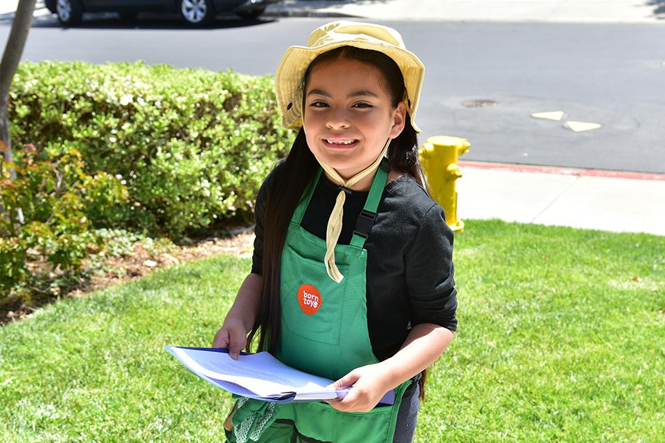 Young water wise gardening guru sits on top of mulch bags