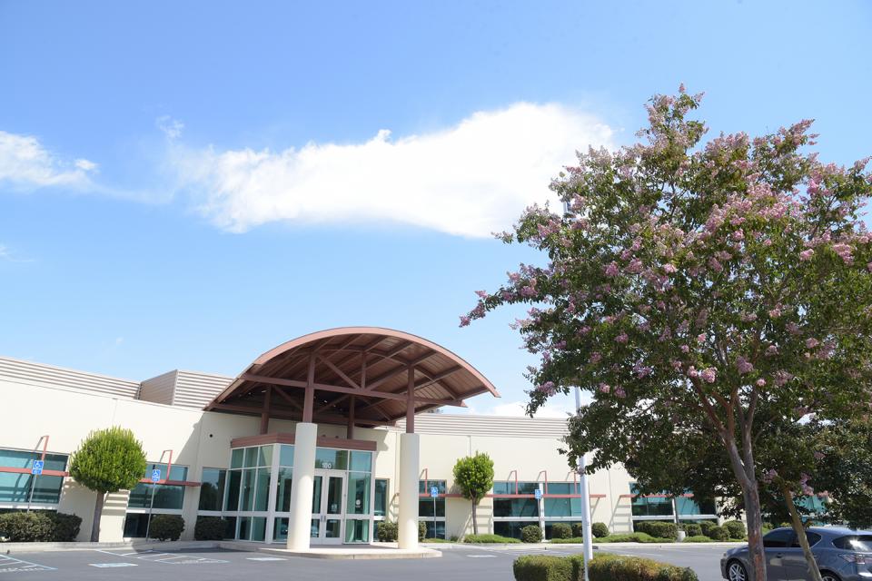 The front of Zone 7's administrative building with blue sky, cloud, and trees