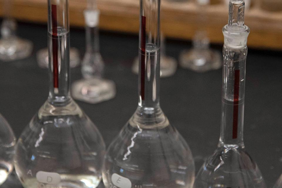 Close up of test tubes and beakers filled with a clear liquid