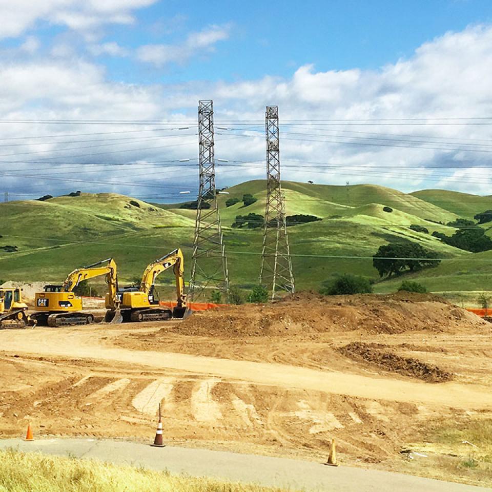 Area of Del Valle Water Treatment plant with powerlines and green hills in the background