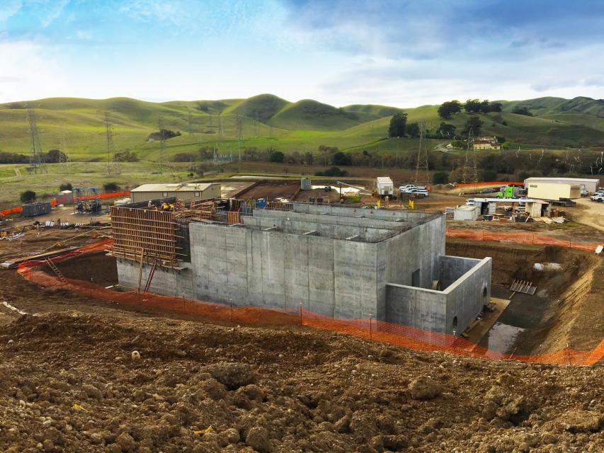 Construction site with cement building being worked on.