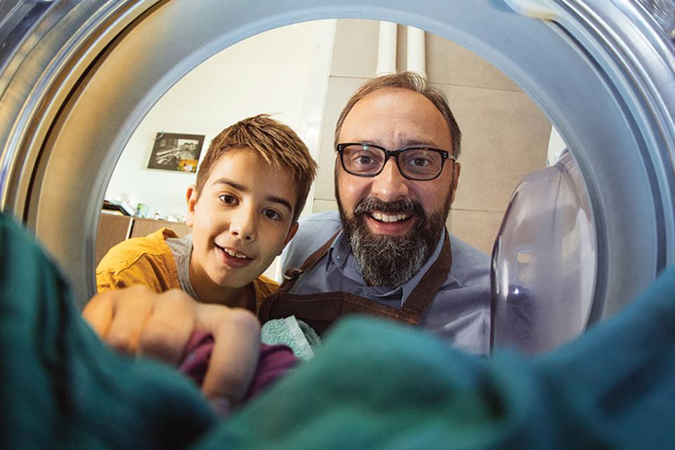 View from inside of a drying machine of a boy and a man looking in